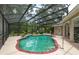 The screened-in pool includes a built-in waterfall and is surrounded by colorful plantings at 4893 Sw 4Th Cir, Ocala, FL 34471