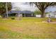 Green house with a large yard, mature trees, and landscaping at 7653 Sw 103Rd Loop, Ocala, FL 34476