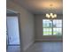 A dining area showcases an elegant chandelier and a large window offering backyard views at 5892 Sw 82Nd Ln, Ocala, FL 34476