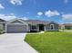 Charming one-story home featuring a well-manicured lawn and attached two car garage at 5892 Sw 82Nd Ln, Ocala, FL 34476