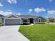 Charming one-story home featuring a well-manicured lawn and attached two car garage at 5892 Sw 82Nd Ln, Ocala, FL 34476