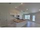 An open kitchen features modern appliances, white cabinets, granite counters and an island with a sink at 5892 Sw 82Nd Ln, Ocala, FL 34476
