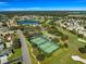 Aerial view of the community's amenities featuring a beautiful lake and tennis courts at 7290 Se 172Nd Legacy Ln, The Villages, FL 32162