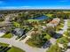 Aerial view of home with lush landscaping near a pond and golf course at 7290 Se 172Nd Legacy Ln, The Villages, FL 32162
