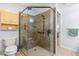 Bathroom showcasing tiled walk-in shower with glass enclosure and a built-in seat, with convenient grab bars installed at 7290 Se 172Nd Legacy Ln, The Villages, FL 32162