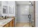 Bright bathroom featuring a single sink vanity, granite countertops, and a tiled walk-in shower with glass enclosure at 7290 Se 172Nd Legacy Ln, The Villages, FL 32162