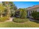 Landscaped backyard featuring lush greenery and a charming sunroom at 7290 Se 172Nd Legacy Ln, The Villages, FL 32162