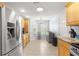 Bright kitchen featuring stainless steel appliances, tile flooring, and light wood cabinetry at 7290 Se 172Nd Legacy Ln, The Villages, FL 32162