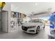 Spacious garage with epoxy floors, storage racks, and a sleek white car parked inside at 9617 Sw 102Nd Ter, Ocala, FL 34481