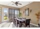 Inviting screened-in porch with a rustic dining set, string lights, and a decorative ceiling fan at 9617 Sw 102Nd Ter, Ocala, FL 34481