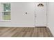 Bright interior room featuring laminate wood flooring and a white door at 13299 Se 45Th Avenue, Belleview, FL 34420