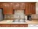 Traditional kitchen with wooden cabinets, stainless steel sink, and patterned backsplash at 19660 Sw 83Rd Place Rd # C18, Dunnellon, FL 34432