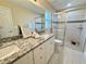 Bathroom featuring double vanity with granite counters, modern fixtures, and a glass-enclosed shower at 9285 Se Highway 42, Summerfield, FL 34491