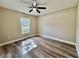 Bedroom features new wood-look flooring, ceiling fan, and a window at 9285 Se Highway 42, Summerfield, FL 34491