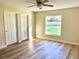 Bedroom features new wood-look flooring, ceiling fan, two closets, and a large window at 9285 Se Highway 42, Summerfield, FL 34491