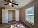 Bedroom featuring wood-look flooring, ceiling fan, and window overlooking the yard at 9285 Se Highway 42, Summerfield, FL 34491