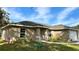 One-story house with tan exterior, landscaping, and a walkway at 9285 Se Highway 42, Summerfield, FL 34491