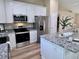 Modern kitchen features stainless steel appliances, granite countertops, white cabinets, and an island at 9285 Se Highway 42, Summerfield, FL 34491