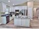 The spacious kitchen includes a large kitchen island, granite countertops, and stainless steel appliances at 9285 Se Highway 42, Summerfield, FL 34491