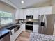 Modern kitchen boasts stainless steel appliances, granite countertops, and white cabinets at 9285 Se Highway 42, Summerfield, FL 34491