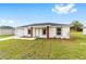Inviting single-Gathering home featuring a lush green lawn and attractive landscaping with wood column accents at 14363 Sw 27 St, Ocala, FL 34481