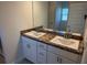 Bathroom featuring double sink vanity with granite countertop and white cabinets at 3106 Ne 46Th Ave, Ocala, FL 34470