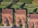 Aerial view showcasing homes with red tile roofs, manicured lawns, and lush landscaping at 5162 Harbour Dr, Oxford, FL 34484