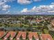 Expansive aerial view of a community with homes surrounding a lake, clubhouse, and pool at 5162 Harbour Dr, Oxford, FL 34484