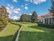 Expansive backyard featuring lush green grass, manicured hedges, and mature trees at 5162 Harbour Dr, Oxford, FL 34484