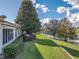 Backyard with a well-maintained lawn, mature trees, and a serene view of the lake at 5162 Harbour Dr, Oxford, FL 34484
