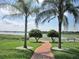 Landscaped backyard with walkway to lake at 5162 Harbour Dr, Oxford, FL 34484