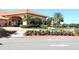 A beautiful entrance to the clubhouse with a circular water fountain, palm trees, and colorful landscaping at 5162 Harbour Dr, Oxford, FL 34484