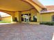 Elegant covered entrance of the clubhouse, featuring meticulously maintained landscaping at 5162 Harbour Dr, Oxford, FL 34484
