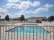 A scenic community pool, framed by lounge chairs, lush trees, and a clear blue sky at 5162 Harbour Dr, Oxford, FL 34484