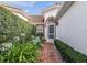 Inviting front entrance with a brick pathway, arched entryway, and lush landscaping at 5162 Harbour Dr, Oxford, FL 34484
