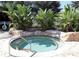 Relaxing hot tub surrounded by lush tropical landscaping and natural rock accents at 5162 Harbour Dr, Oxford, FL 34484