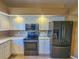 Kitchen view with stainless steel appliances and white cabinets at 5162 Harbour Dr, Oxford, FL 34484