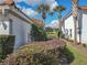 Side yard with lush green landscaping, palm trees, and views of a sprawling green space at 5162 Harbour Dr, Oxford, FL 34484