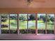 Bright sunroom featuring tranquil view of community pond and fountain at 5162 Harbour Dr, Oxford, FL 34484