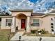 Attractive home entrance with a red front door, decorative wreath, and manicured landscaping at 8335 Se 162Nd Pl, Summerfield, FL 34491