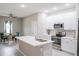 Bright kitchen featuring stainless steel appliances, white cabinets, island and adjacent dining area at 8565 Sw 125Th Court Rd, Dunnellon, FL 34432