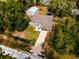Beautifully landscaped home featuring a long driveway and a detached garage surrounded by lush greenery at 12805 Sw 64Th Ln, Ocala, FL 34481
