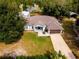 Aerial view displaying the home's landscaping, modern features, and extended driveway with mature trees at 12805 Sw 64Th Ln, Ocala, FL 34481