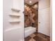 Stylish bathroom featuring tiled walls, a bathtub with shower, and wall shelving for functional storage at 12805 Sw 64Th Ln, Ocala, FL 34481