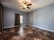 Neutral bedroom with dark tile floors, a ceiling fan, and natural light from one window at 12805 Sw 64Th Ln, Ocala, FL 34481