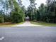 Gated driveway leads to a wooded property with mature trees and lush landscaping at 12805 Sw 64Th Ln, Ocala, FL 34481