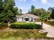 Charming single-story home featuring a manicured lawn with trees and an American flag at 12805 Sw 64Th Ln, Ocala, FL 34481