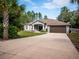 Gray house with a brown garage door and palm trees in the front at 12805 Sw 64Th Ln, Ocala, FL 34481