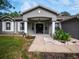 Inviting front porch with decorative columns, gray facade and landscaped garden beds at 12805 Sw 64Th Ln, Ocala, FL 34481