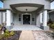 Inviting front porch with decorative columns, gray facade and landscaped garden beds at 12805 Sw 64Th Ln, Ocala, FL 34481